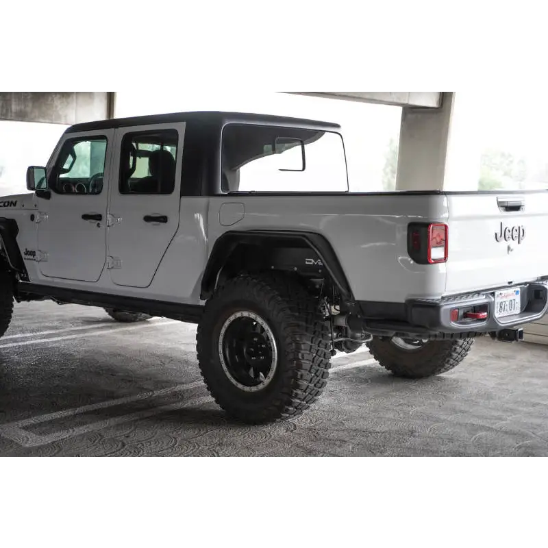 DV8 Offroad Jeep Gladiator JT Spec Series Fender Flares parked in parking lot adjacent to white truck