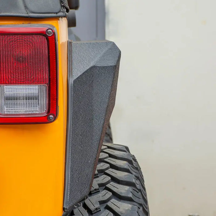 DV8 Offroad 2007-2018 Jeep Wrangler Armor Style Fenders: Rear view of yellow jeep with red tail light.