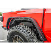 DV8 Offroad Jeep Gladiator Rear Inner Fenders - Black: Red truck with big tire in parking lot