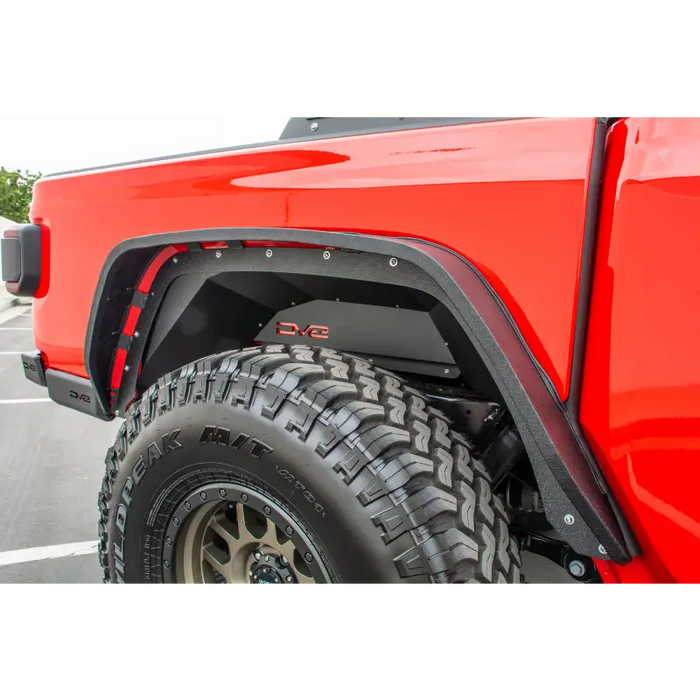 DV8 Offroad Jeep Gladiator Rear Inner Fenders - Black: Red truck with big tire in parking lot