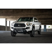 White truck parked under a bridge - DV8 Offroad Toyota Tacoma Center Bumper.