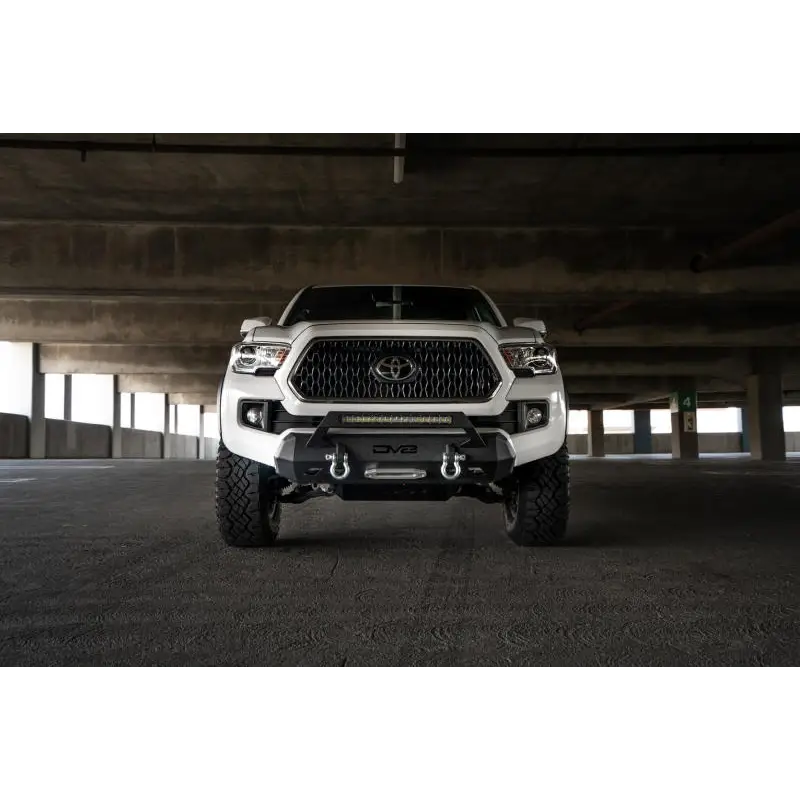 DV8 Offroad 2016+ Toyota Tacoma Center Bumper featuring front end of white truck