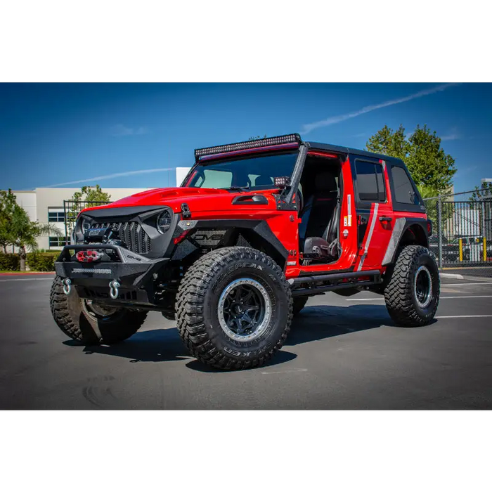 Red Jeep with big tire parked, DV8 Offroad 2018+ Jeep JL/ Gladiator Angry Grill.