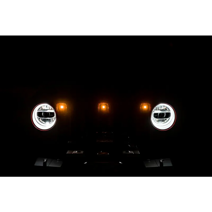 DV8 Offroad 2018+ Jeep JL Grill Amber Marker Lights showcase two headlights in the dark.