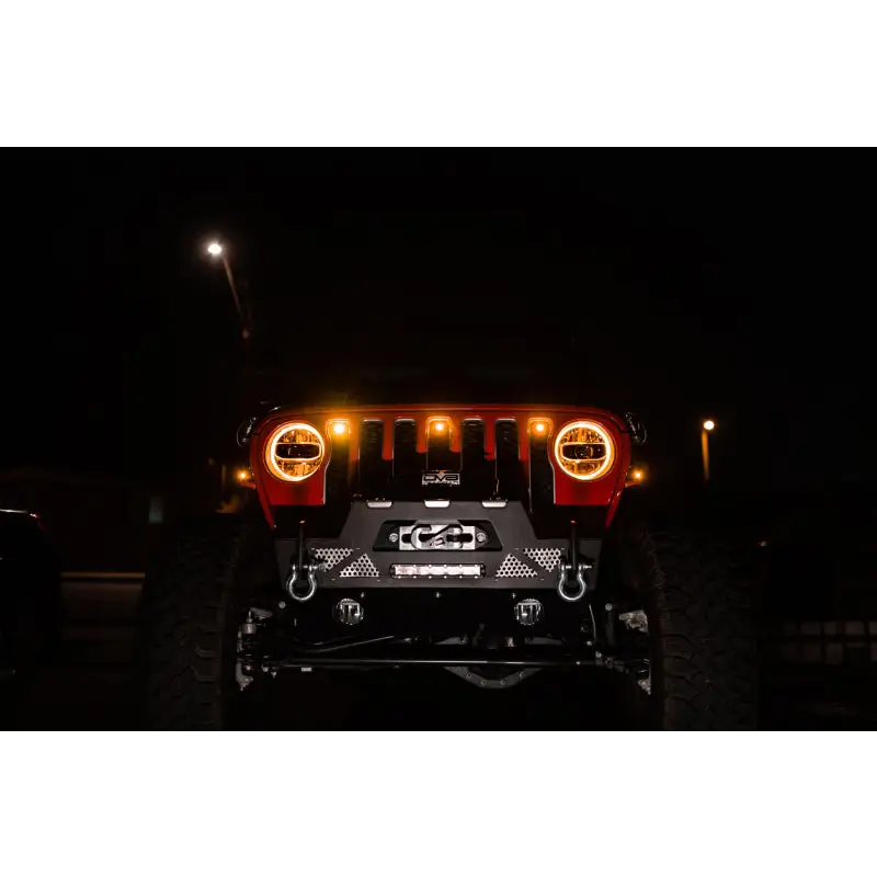 Close up of Jeep JL grill with amber marker lights on at night