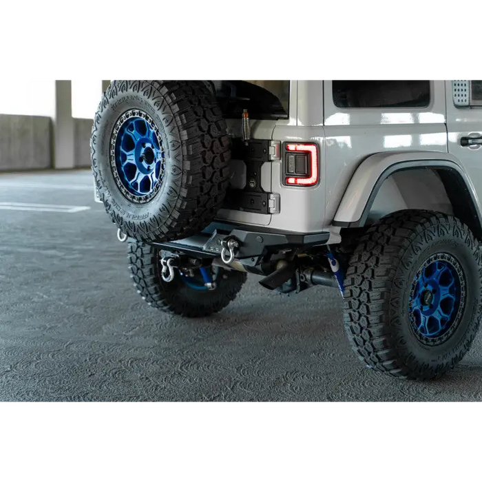 DV8 Offroad 2018 Jeep Wrangler JL FS-15 rear bumper with big tire parked in parking lot