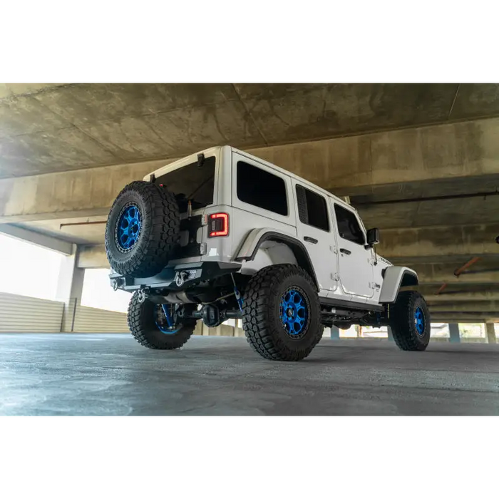 White Jeep with Blue Wheels and Tires on DV8 Offroad 2018 Jeep Wrangler JL MTO Series Rear Bumper.