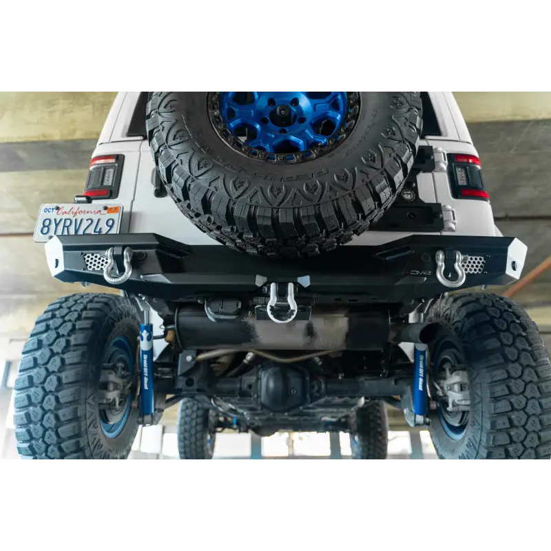 DV8 Offroad 2018 Jeep Wrangler JL MTO Series rear bumper with blue tire on white jeep
