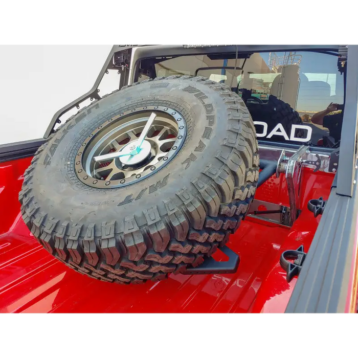DV8 Offroad adjustable tire carrier for Jeep Gladiator with front tire.