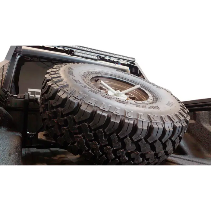 DV8 Offroad 2019+ Jeep Gladiator In-Bed Adjustable Tire Carrier with tire on jeep