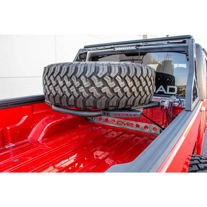 Red truck with large tire on bed - DV8 Offroad adjustable tire carrier