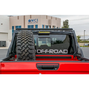 Red truck with large tire on back displayed on DV8 Offroad 2019+ Jeep Gladiator Bolt On Chase Rack.