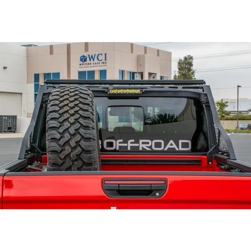 Red truck with large tire on back displayed on DV8 Offroad 2019+ Jeep Gladiator Bolt On Chase Rack.