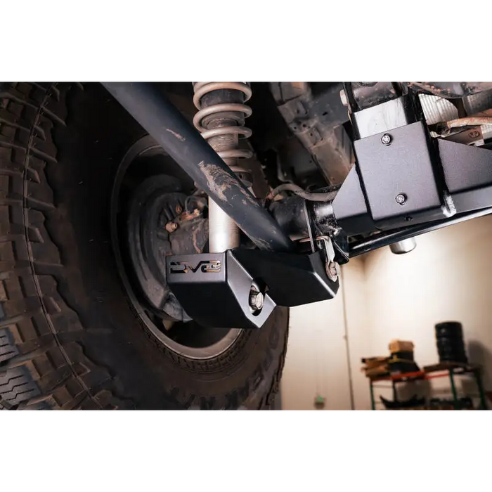 Man working on Ford Bronco rear shock guard skid plates at DV8 Offroad.
