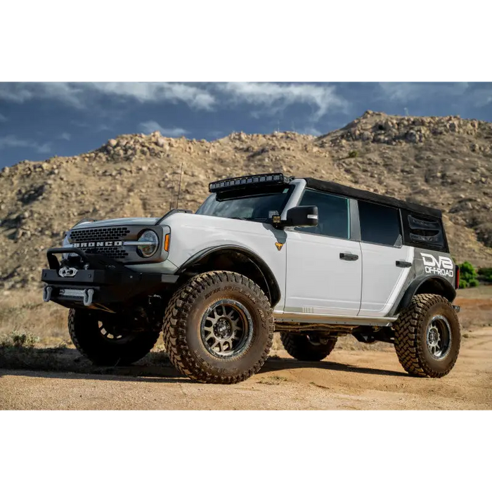 White truck parked on dirt road with DV8 Offroad 2021 Ford Bronco A Pillar Dual Light Pod Drop Mounts.