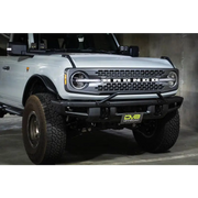 White truck with big bumper and license plate relocation bracket - DV8 Offroad Ford Bronco.