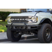 White truck with big front bumper, license plate relocation bracket for Ford Bronco.