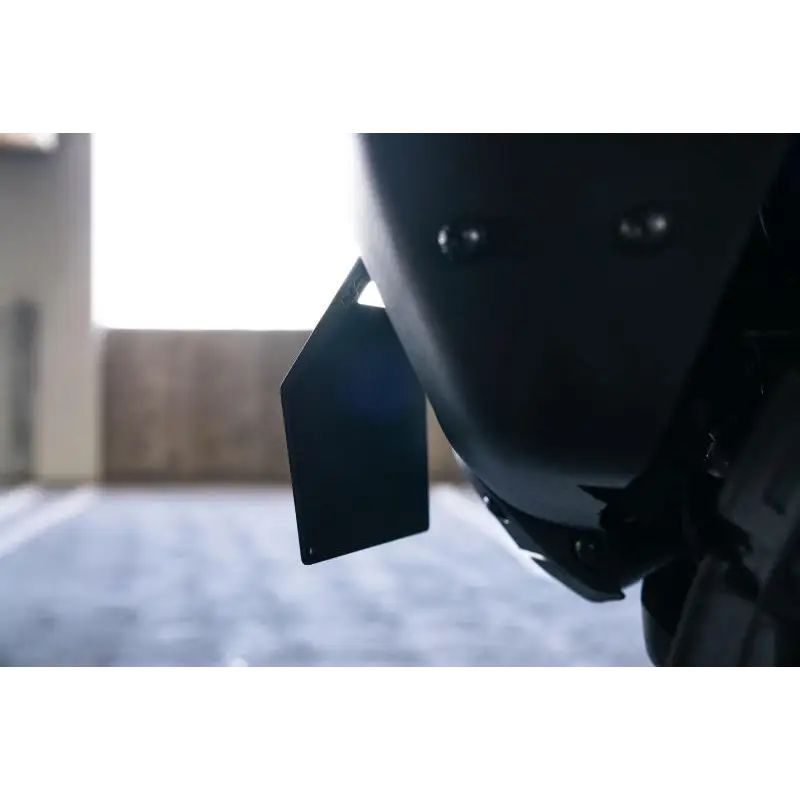 Close-up of motorcycle helmet with attached tag, DV8 Offroad license plate relocation bracket.