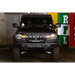 Black Land Rover parked in garage next to DV8 Offroad 21-22 Ford Bronco Factory Modular Front Bumper Bull Bar.