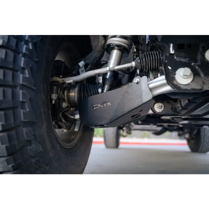 Close up of front suspension on motorcycle with DV8 Offroad Ford Bronco Front Lower Control Arm Skid Plate