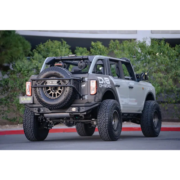 DV8 Offroad 21-22 Ford Bronco FS-15 Series Rock Sliders with large tire on back of truck