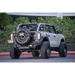 DV8 Offroad 21-22 Ford Bronco FS-15 Series Rock Sliders with large tire on back of truck