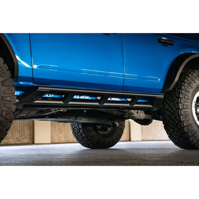 Blue truck with large tire on DV8 Offroad 21-22 Ford Bronco FS-15 Series Rock Sliders.