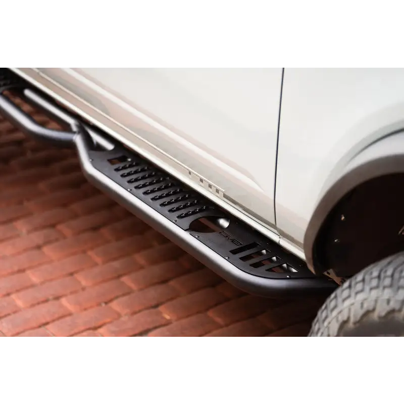 Close up of car tire on brick road - DV8 Offroad 21-22 Ford Bronco side steps