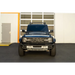 Blue truck parked in front of building with DV8 Offroad hard top roof rack and light bar mount.