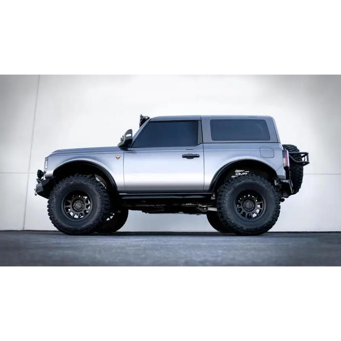 Silver offroad truck with big tire - DV8 Offroad 21-23 Ford Bronco OE Plus 2-Door Side Steps.