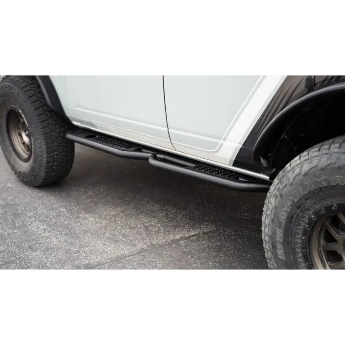 White Ford Bronco with black side step bars by DV8 Offroad - pinch weld covers.