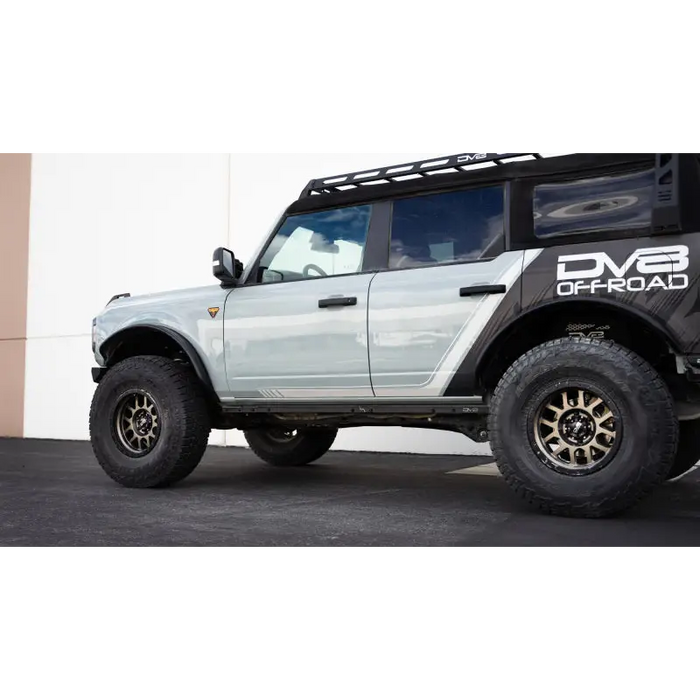White truck with black roof rack displaying DV8 Offroad 21-23 Ford Bronco Pinch Weld Covers.