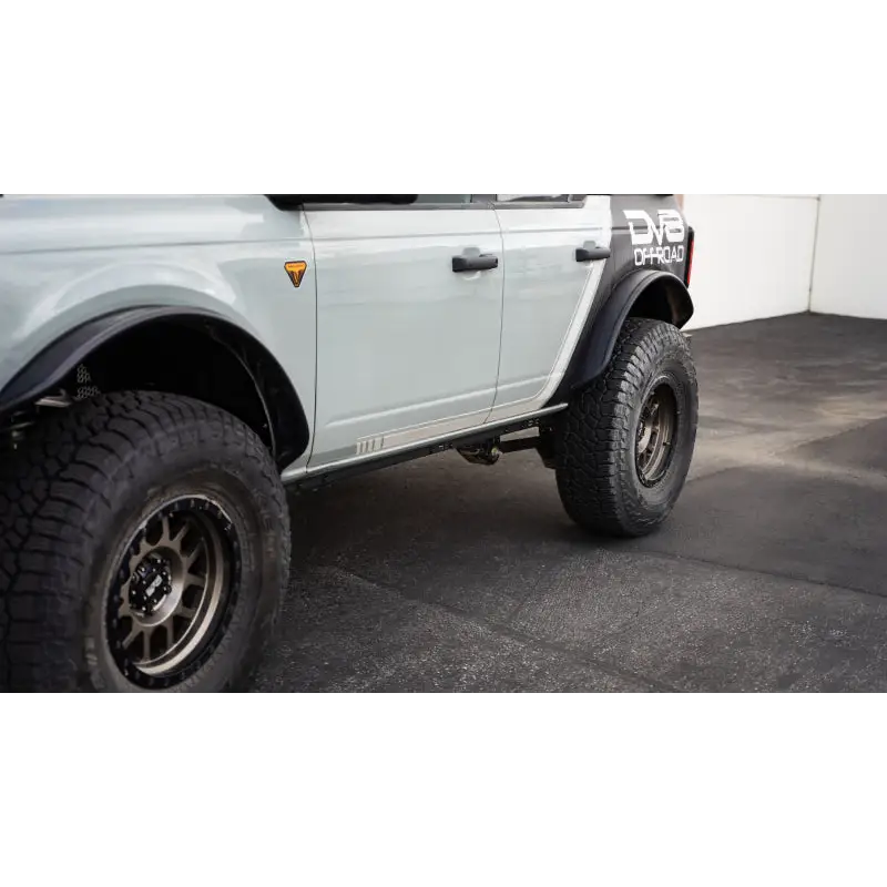 DV8 Offroad white truck with black tire Pinch Weld Covers for Ford Bronco