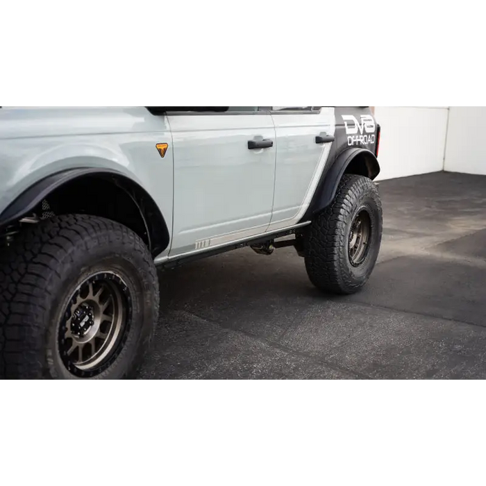 DV8 Offroad white truck with black tire Pinch Weld Covers for Ford Bronco