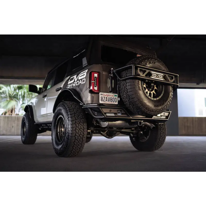 DV8 Offroad Ford Bronco rear license plate relocation bracket with black jeep and large tire.