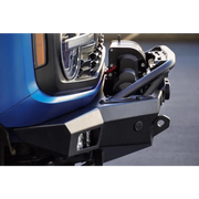 Blue Ford Bronco front bumper with open door by DV8 Offroad - Spec Series design with skid plate and light bar.