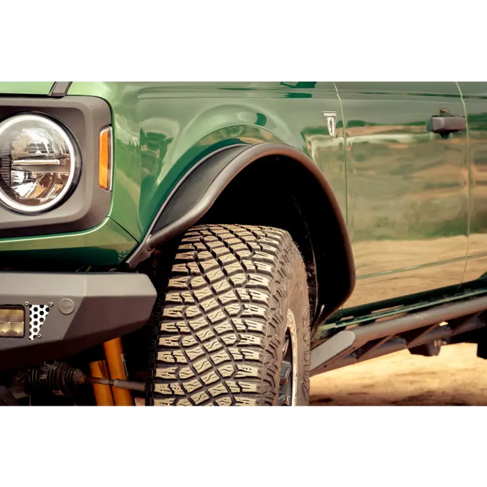 Green truck with light - DV8 Offroad Ford Bronco fender flares.