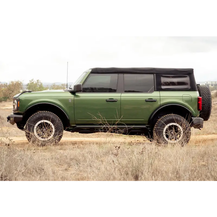 Green Jeep parked in grass field with DV8 Offroad 21-23 Ford Bronco Tube Fender Flares