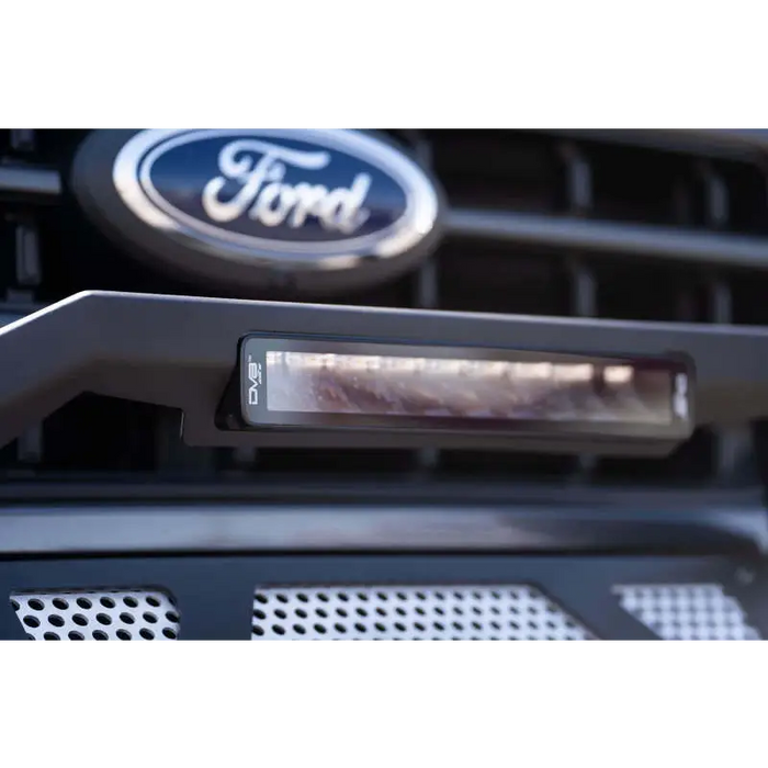 Close-up of Ford badge on car grille with DV8 Offroad Elite Series 13in Light Bar - 45W Flood/Spot LED