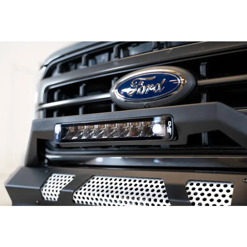 Close up of Ford truck grill with blue Ford logo on DV8 Offroad Elite Series 13in Light Bar 45W Flood/Spot LED.