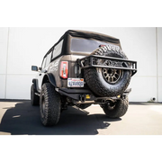 Black Jeep with large tire showcasing DV8 Offroad Elite Series D-Ring Shackles - Pair in Gray.