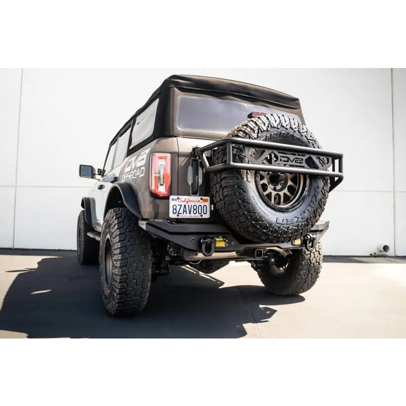 Black Jeep with large tire showcasing DV8 Offroad Elite Series D-Ring Shackles - Pair in Gray.