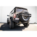 Black Jeep with large tire showcasing DV8 Offroad Elite Series D-Ring Shackles - Pair in Gray.