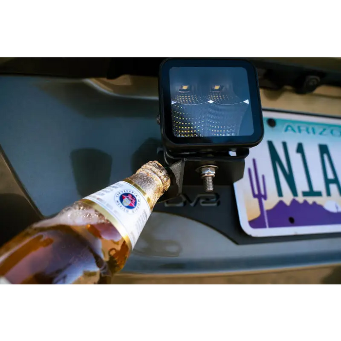 Universal License Plate Mount with Pod Light Mounts featuring a hand holding a beer bottle.