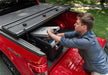 Man loading box into red truck bed - extang solid fold alx