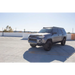 Silver Toyota SUV parked in a parking lot next to a Go Rhino 10-23 Toyota 4Runner Ceros Low Profile Roof Rack - Tex. Blk.