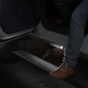 Man sitting on steps of car - Go Rhino electric running board kit in Tex. Blk color