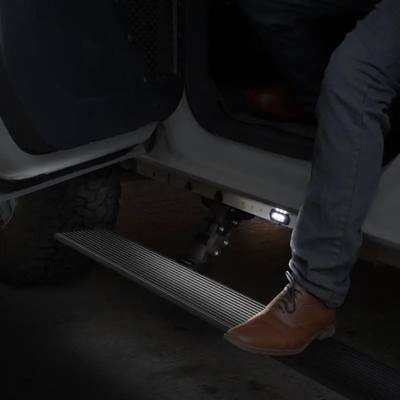 Man sitting on steps of car - Go Rhino electric running board kit in Tex. Blk color