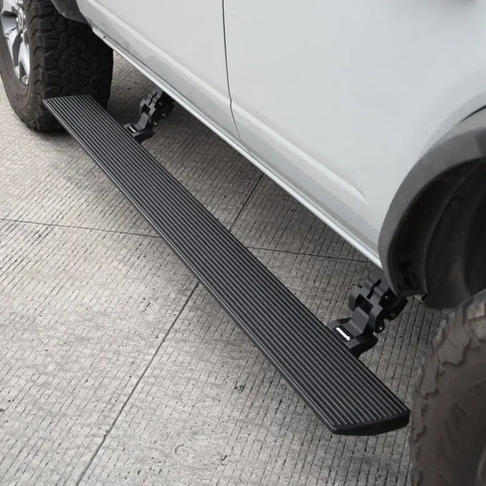 White truck with black side step - Go Rhino electric running board kit for Ford Bronco.