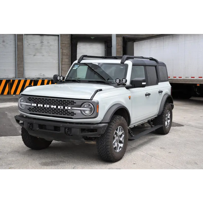 White truck parked in front of a building with electric running board